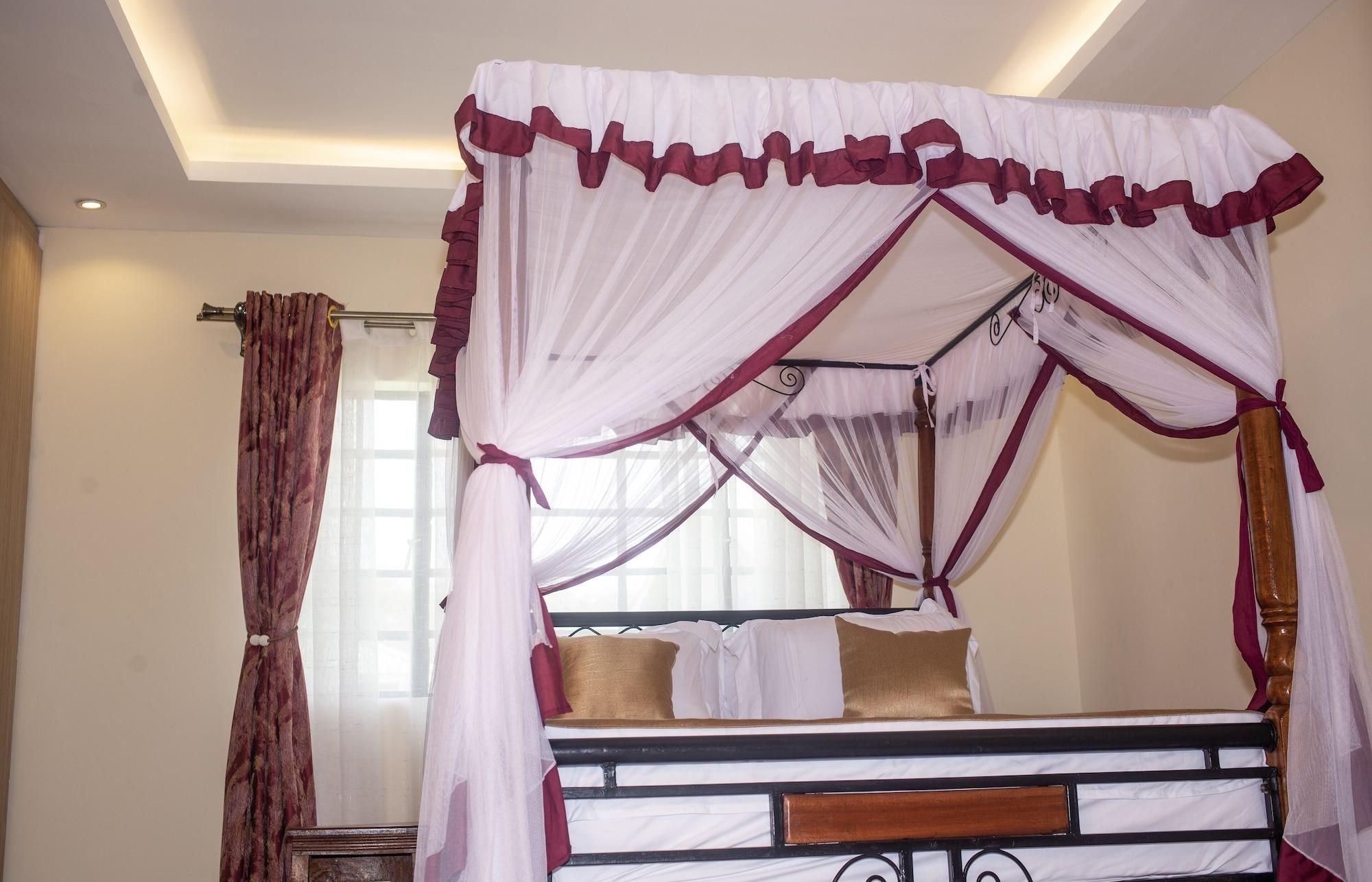 A four-poster canopy bed with a wooden frame and white bedding.