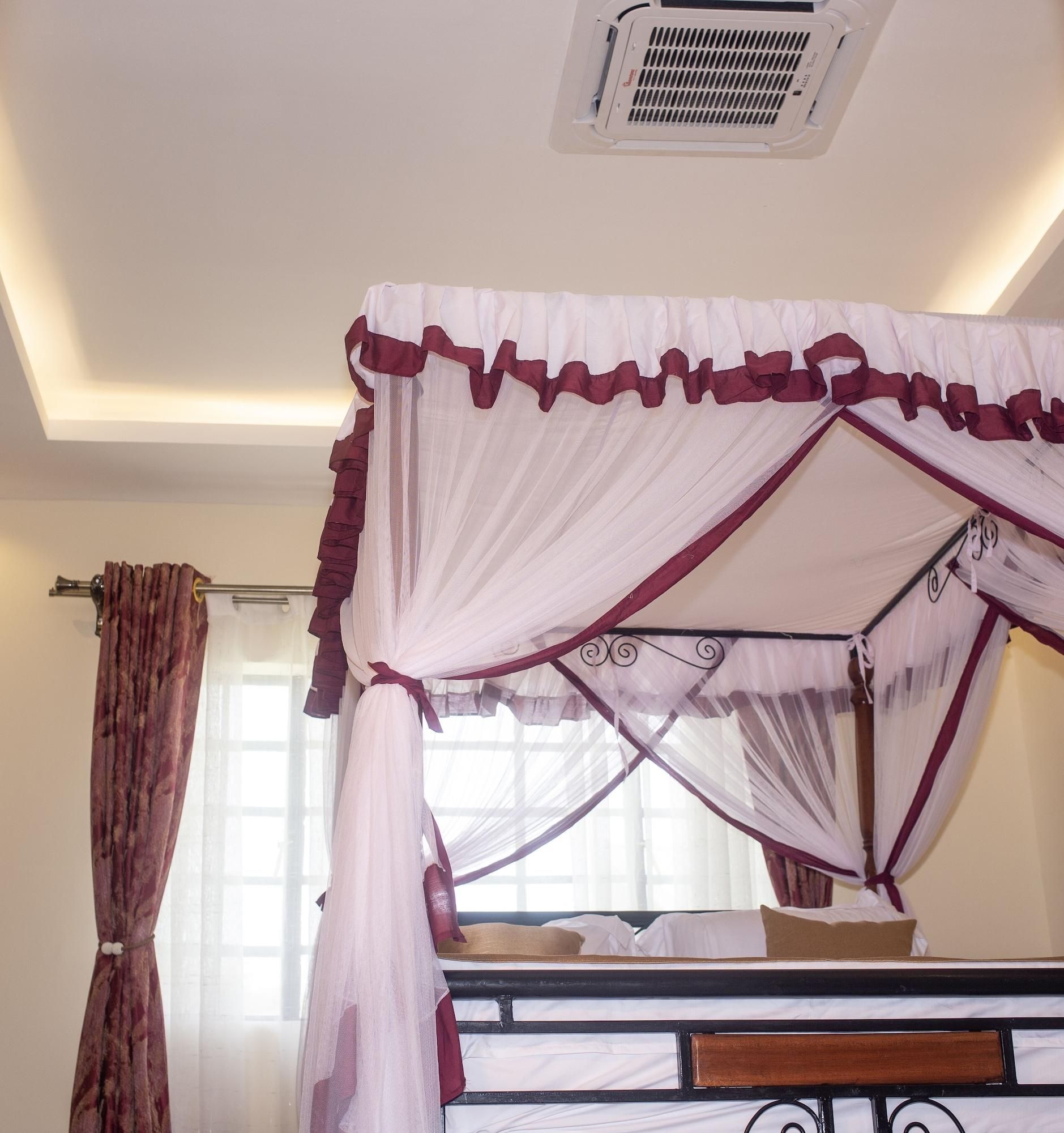 Ein Schlafzimmer mit einem Bett, einem Fenster mit Vorhängen und einer Klimaanlage an der Decke.