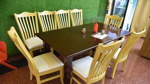 Une table à manger avec six chaises, un menu et des condiments.