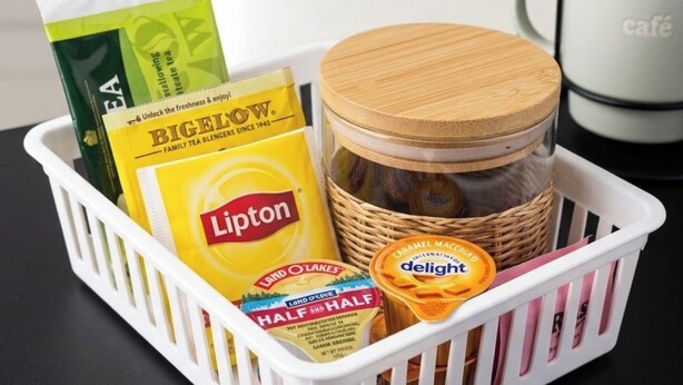 Una cesta con bolsitas de té Lipton, un tarro de café con caramelo y leche crema.