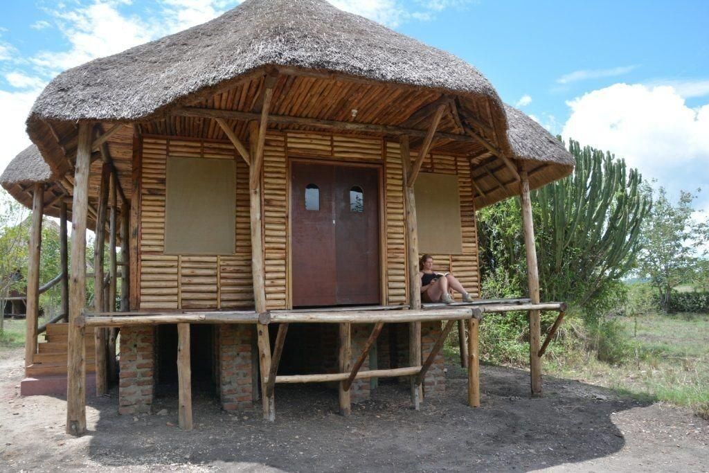 A rustic wooden structure with a thatched roof and a wooden porch.