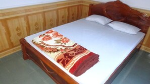 Ein Bett mit einer blumigen Tagesdecke und zwei Kissen.