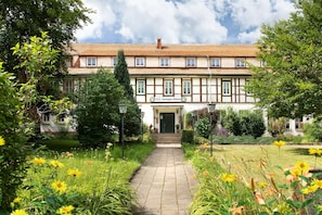 A traditional half-timbered building with a garden pathway leading to the entrance. - Sandgut Mihla (Bad Salzungen)