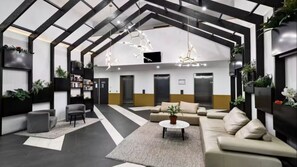 A modern lobby with a high ceiling, geometric ceiling design, and a central seating area with a sofa and coffee table. - The Yarra Terrace | 3BR with Pool & Parking (Abbotsford)