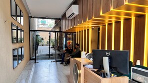 A reception desk with a computer, a fan, and a wooden panel design. - Hamsun (Karachi)