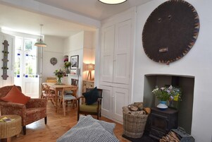 A cozy living room with a fireplace, wooden furniture, and a dining area.