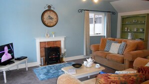 A living room with a fireplace, a television, and a sofa. - High Grange Cottages (Bedale)