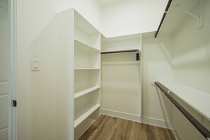 Un vestidor con estantes abiertos y barra para colgar.