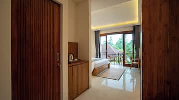 Habitación de hotel con armario de madera, cama, una mesita con hervidor y vistas al exterior.