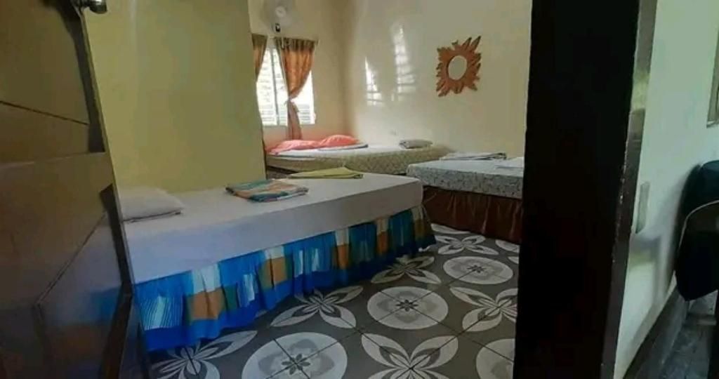 Una habitación pequeña con cama, escritorio y ventana con cortinas.
