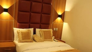 Een hotelkamer met een groot bed, twee nachtkastjes en wandlampen.