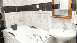 Een moderne badkamer met een wit bad, een wastafel en een spiegel.