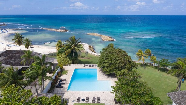 Un complexe hôtelier doté d’une piscine, d’une plage et offrant une vue sur l’océan.