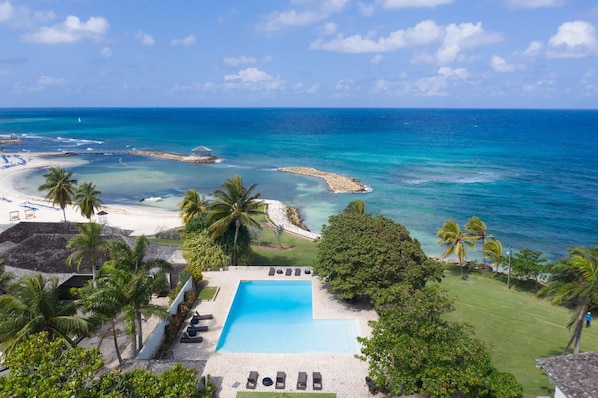 Resort com piscina, praia e vista para o mar.