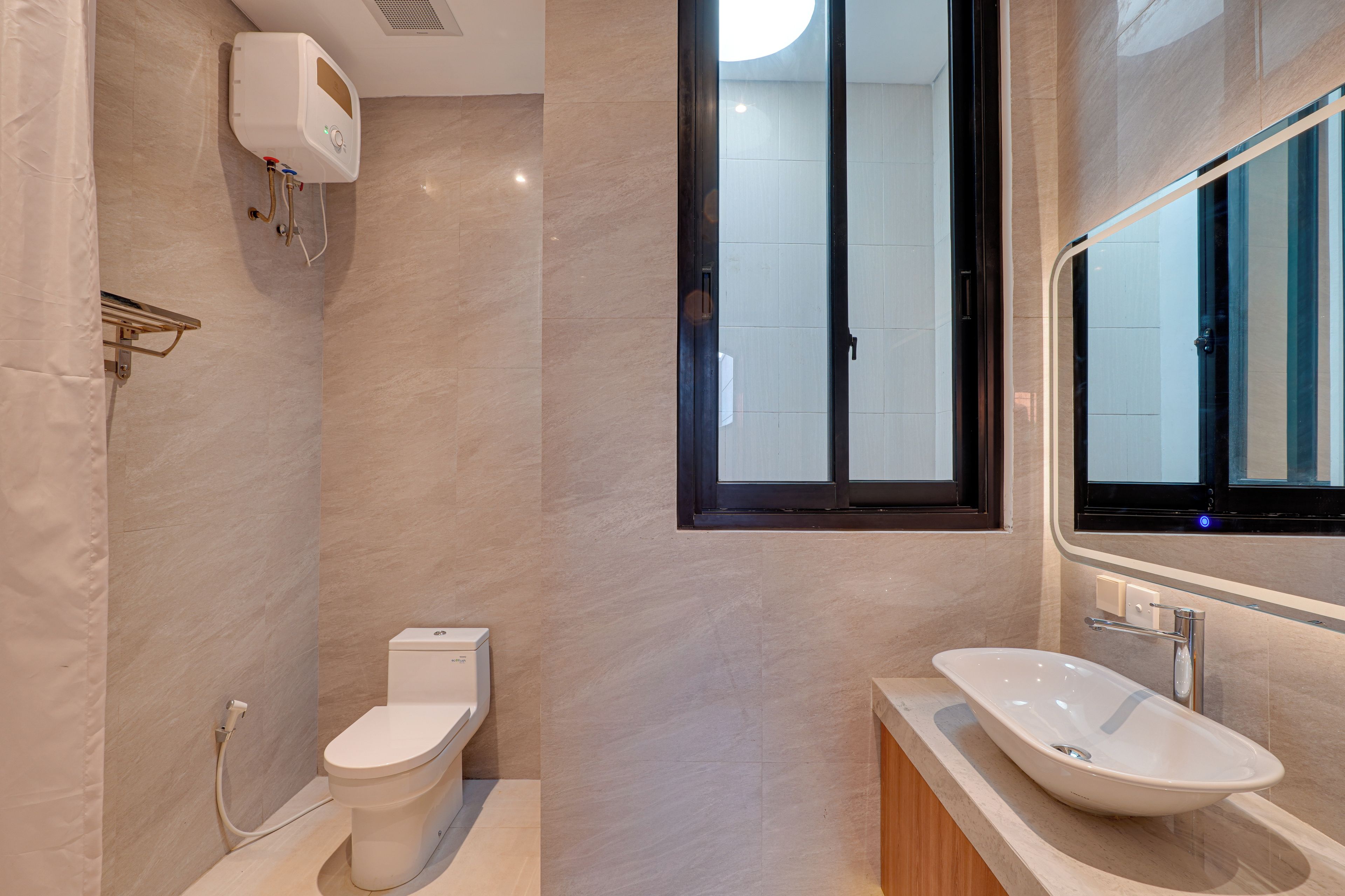 A modern bathroom with a toilet, bidet, and a large mirror.