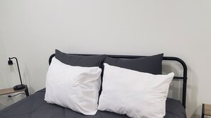A bed with a black metal frame, two white pillows, and a grey mattress. - 4bedroom home in amazing Atlanta conveniently located no matter what your plans. (Atlanta)
