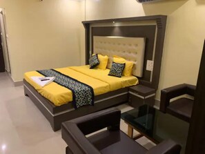 Ein Schlafzimmer mit einem Bett, Nachttischen und einem Sessel.