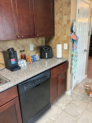 A kitchen with a dishwasher, a coffee maker, and a microwave. - Entire Katy cozy home (Katy)