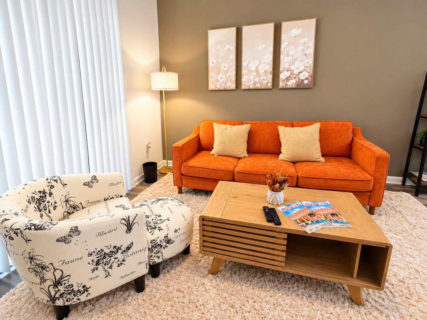 A living room with a sofa, a coffee table, a lamp, and a wall with three framed pictures.