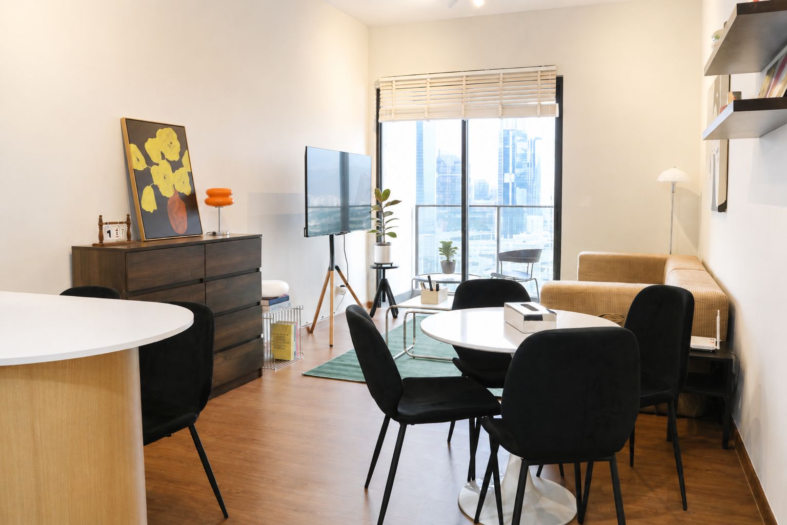 Una sala de estar moderna con comedor, televisor de pantalla plana, sofá y vista a la ciudad a través de amplios ventanales.