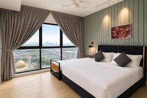 A modern hotel room with a large bed, a view of a cityscape, and a ceiling fan. - Nusareka Homestay (Kuala Lumpur)