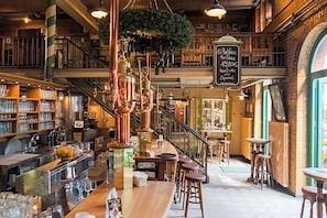 Eine Bar mit Treppe, Barhocker und einer hängenden Pflanze.