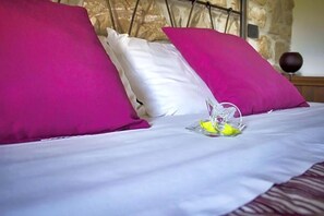A bed with white bedding and two bright pink pillows. - Masseria Monte Pizzi (Carovilli)