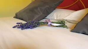 A bed with white bedding, two pillows, a bouquet of lavender, and a small purple bow. - Masseria Monte Pizzi (Carovilli)