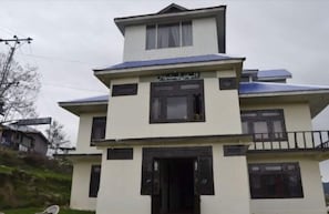 A multi-story building with a flat roof and a balcony on the second floor. - Al Pine Guest House (Balakot)