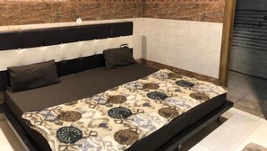 Una habitación con cama, aire acondicionado de pared y paneles de madera.