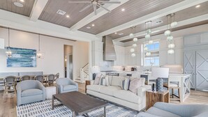 A spacious living room with a sofa, chairs, a coffee table, and a patterned rug. - Boardwalk Breeze 109 Sou (Port Aransas)