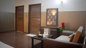 A hotel lobby with a reception desk, a sofa, and a door. - Mall View Hotel Gulberg (Lahore)