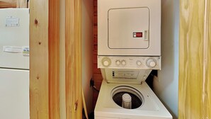 Ein kleiner Hauswirtschaftsraum mit einer übereinander angeordneten Waschmaschine und einem Trockner.