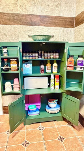 A green kitchen cabinet with various food items and kitchenware. - Spacious 5-bedroom house in peaceful Fairbanks
Walk in downtown (Fairbanks)