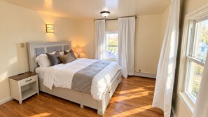 A bedroom with a bed, bedside tables, a lamp, and a window with curtains. - Spacious 5-bedroom house in peaceful Fairbanks
Walk in downtown (Fairbanks)
