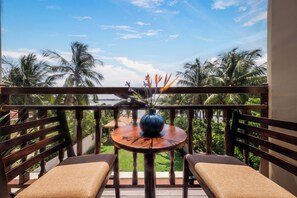 A balcony with two wooden chairs, a round wooden table, and a vase with flowers. - An Hoi Riverside Grand Hotel & Spa (Da Nang)