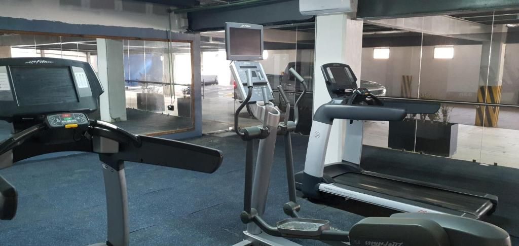 A gym with cardio equipment including treadmills and elliptical machines.