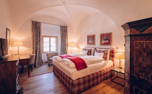 Una habitación de hotel con una cama, un escritorio, una silla y un armario.