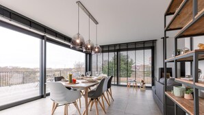 Un comedor moderno con una mesa grande, sillas e iluminación colgante.