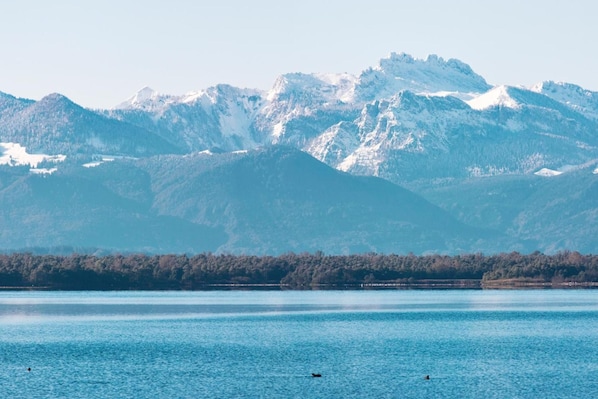 A lake with mountains in the background. - Hotel Garni Georgenhof Adults Only (Rimsting)