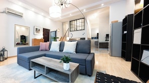 A modern living room with a sectional sofa, a wooden coffee table, and a large mirror. - Innocondo Extended Stay Changning Yuyuan (Shanghai)