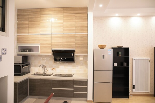 A modern kitchen with built-in appliances, a microwave, a stove, and a refrigerator.