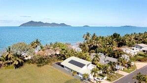 A coastal residential area with houses, palm trees, and a view of the ocean. - The Barrington- Ocean Front Views (Wongaling Beach)