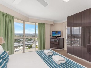 A hotel room with a large bed, a TV, a desk, and a view of the city. - Burleigh Surf 18th Floor Spectacular Ocean Views (Gold Coast)