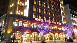 A multi-story hotel with a prominent sign, balconies, and a well-lit entrance. - Hotel Konigs Krone Kobe (Kobe)