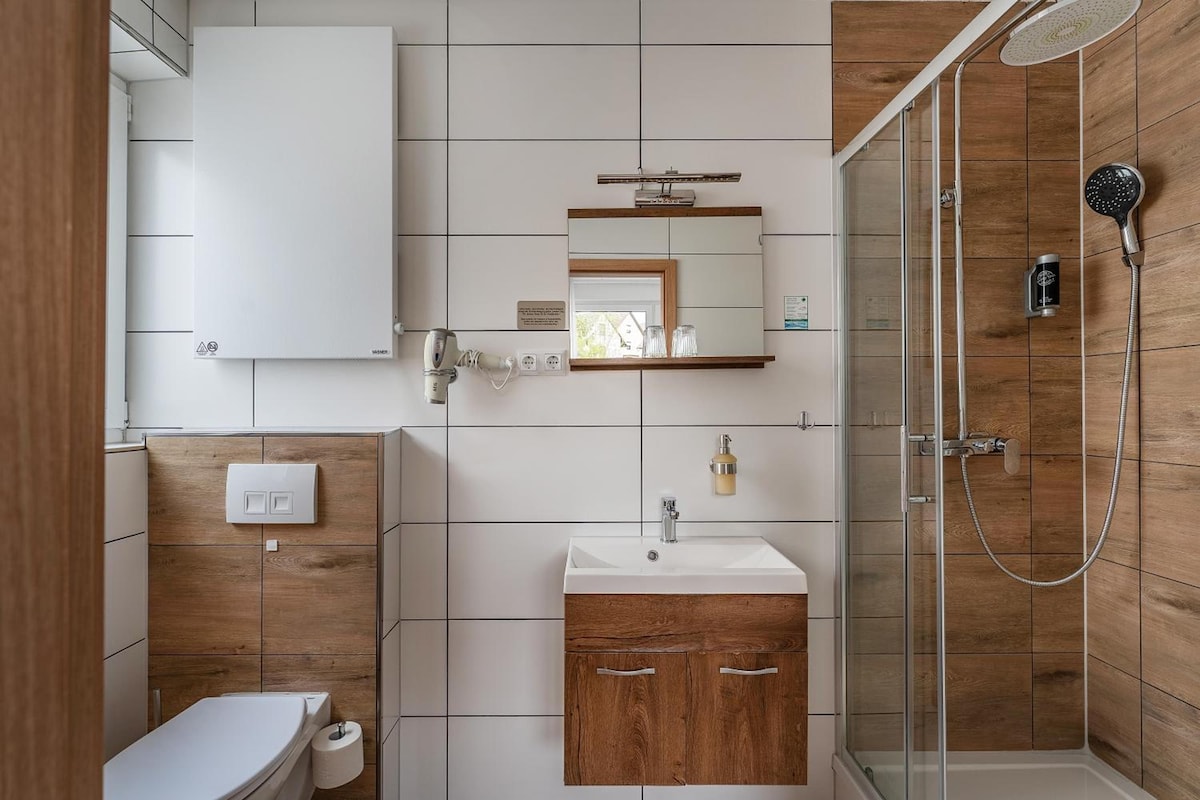 A modern bathroom with a shower, toilet, and sink.