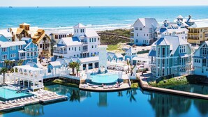 A coastal resort with multiple buildings, a central pool, and a view of the ocean. - Walking On Sunshine 246 Lak (Port Aransas)