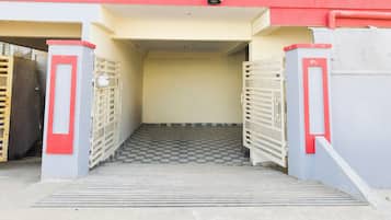 Una entrada con reja y una escalera metálica que conduce a un espacio cubierto.