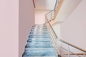 A staircase with metal railings and a handrail, leading to an upper floor. - OYO Hotel O Ramarvapadu (Vijayawada)