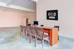 Ein Hotelrezeptionsbereich mit einem Holztisch, einem Computer und einem Schild, das anzeigt, dass der Hotelbetrieb firmengeführt ist.
